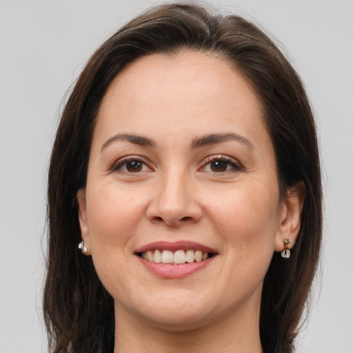 Joyful white young-adult female with long  brown hair and brown eyes