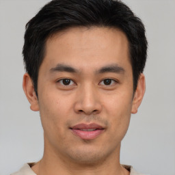 Joyful asian young-adult male with short  brown hair and brown eyes