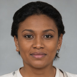 Joyful black young-adult female with short  brown hair and brown eyes