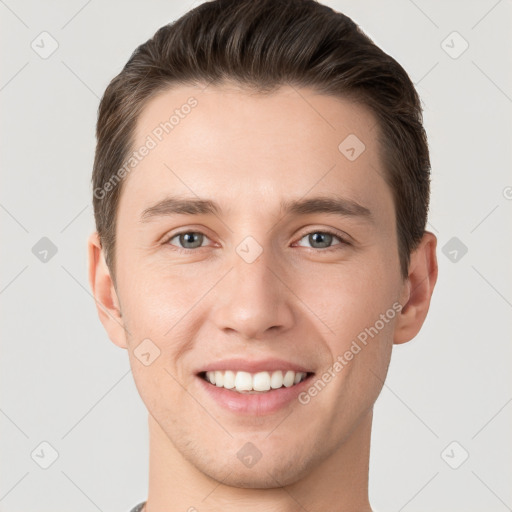 Joyful white young-adult male with short  brown hair and grey eyes