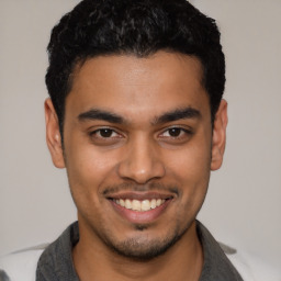 Joyful latino young-adult male with short  black hair and brown eyes