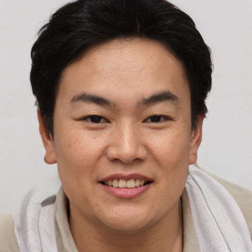 Joyful asian adult male with short  brown hair and brown eyes
