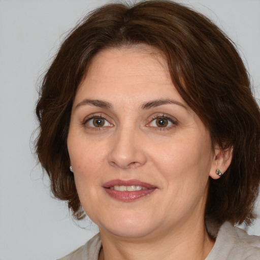 Joyful white adult female with medium  brown hair and brown eyes