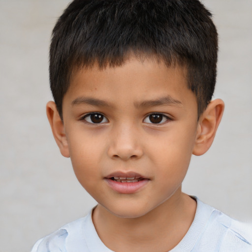 Joyful latino child male with short  brown hair and brown eyes