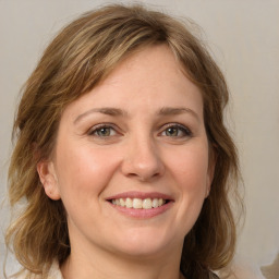 Joyful white young-adult female with medium  brown hair and green eyes