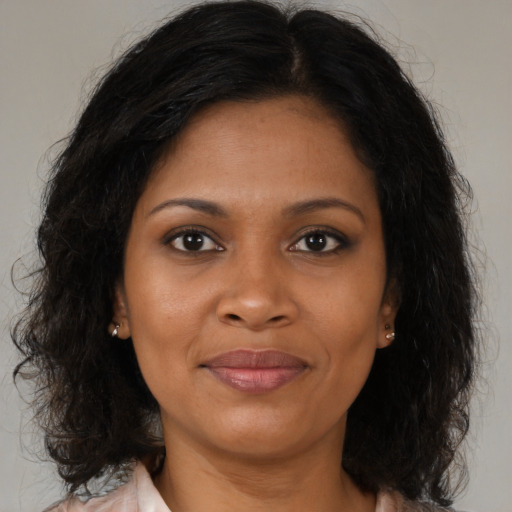Joyful black adult female with medium  brown hair and brown eyes