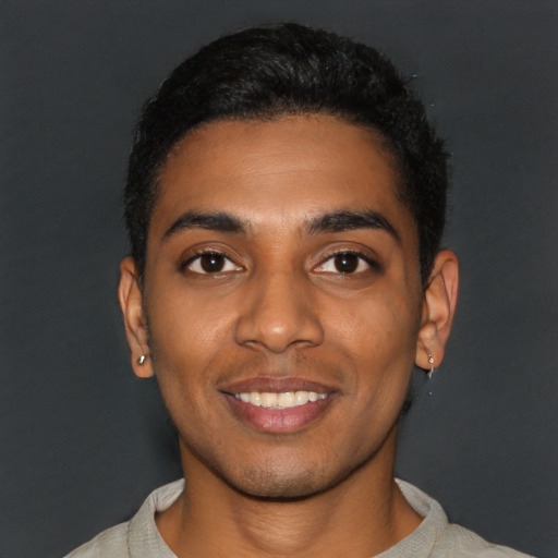 Joyful black young-adult male with short  black hair and brown eyes