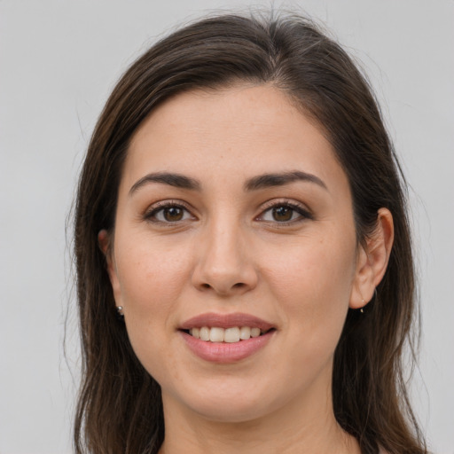 Joyful white young-adult female with long  brown hair and brown eyes