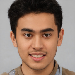 Joyful latino young-adult male with short  brown hair and brown eyes