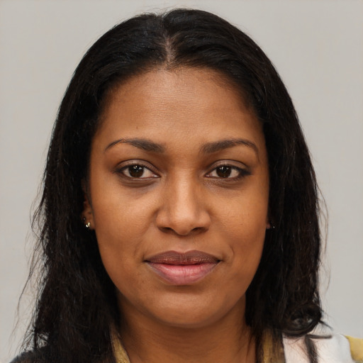 Joyful black young-adult female with long  brown hair and brown eyes