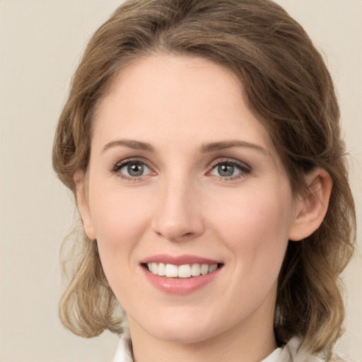 Joyful white young-adult female with medium  brown hair and green eyes