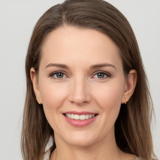 Joyful white young-adult female with long  brown hair and grey eyes