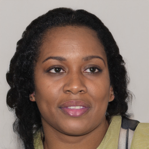 Joyful black adult female with medium  brown hair and brown eyes
