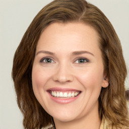 Joyful white young-adult female with long  brown hair and green eyes