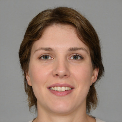 Joyful white young-adult female with medium  brown hair and green eyes