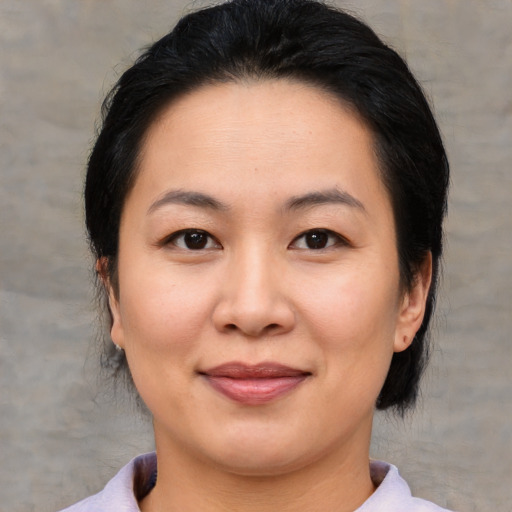 Joyful asian adult female with medium  brown hair and brown eyes