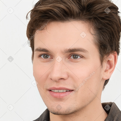 Joyful white young-adult male with short  brown hair and grey eyes