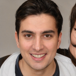 Joyful white young-adult male with medium  brown hair and brown eyes