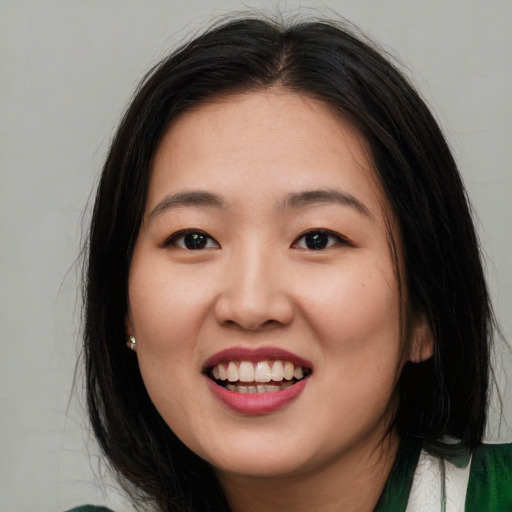 Joyful asian young-adult female with long  brown hair and brown eyes