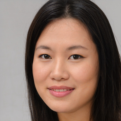 Joyful asian young-adult female with long  brown hair and brown eyes