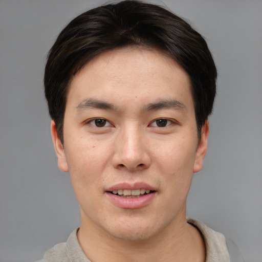 Joyful asian young-adult male with short  brown hair and brown eyes