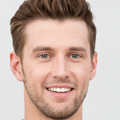 Joyful white young-adult male with short  brown hair and grey eyes