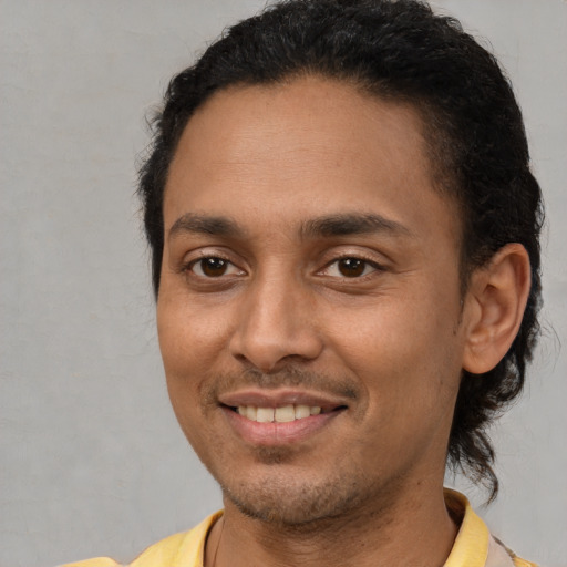 Joyful latino young-adult male with short  black hair and brown eyes