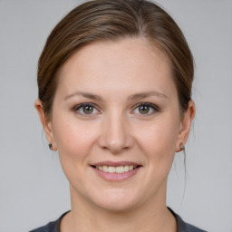 Joyful white young-adult female with medium  brown hair and grey eyes