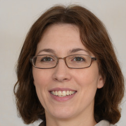 Joyful white adult female with medium  brown hair and green eyes