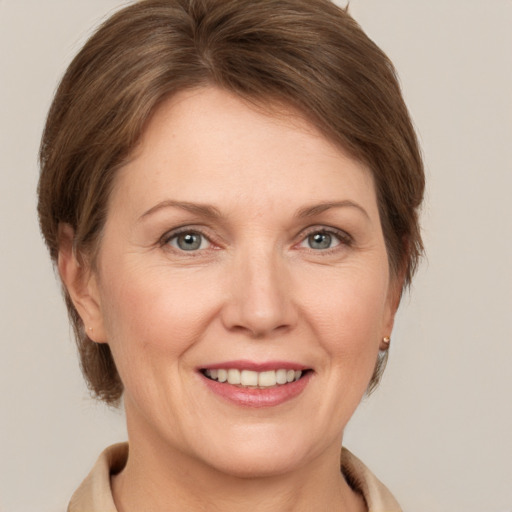 Joyful white adult female with medium  brown hair and grey eyes