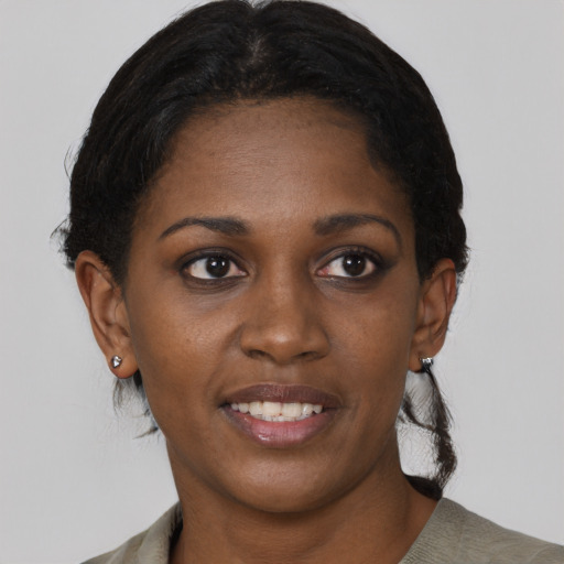 Joyful black young-adult female with short  black hair and brown eyes