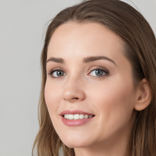 Joyful white young-adult female with long  brown hair and grey eyes