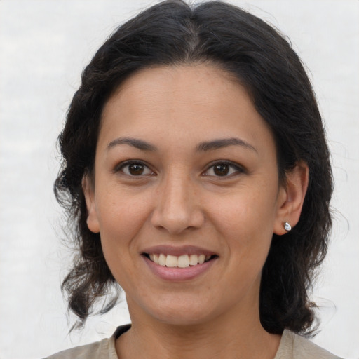 Joyful latino adult female with medium  brown hair and brown eyes