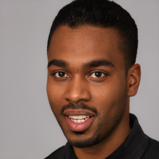 Joyful black young-adult male with short  black hair and brown eyes