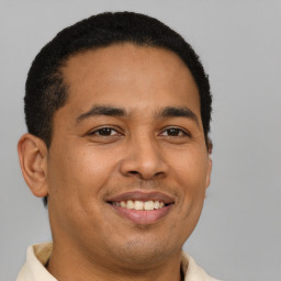 Joyful latino young-adult male with short  brown hair and brown eyes