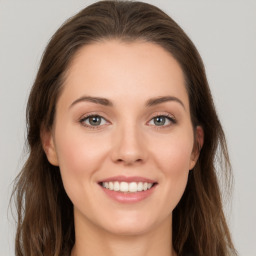 Joyful white young-adult female with long  brown hair and green eyes