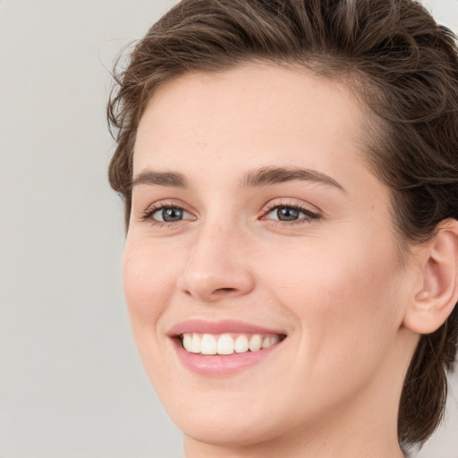 Joyful white young-adult female with medium  brown hair and green eyes