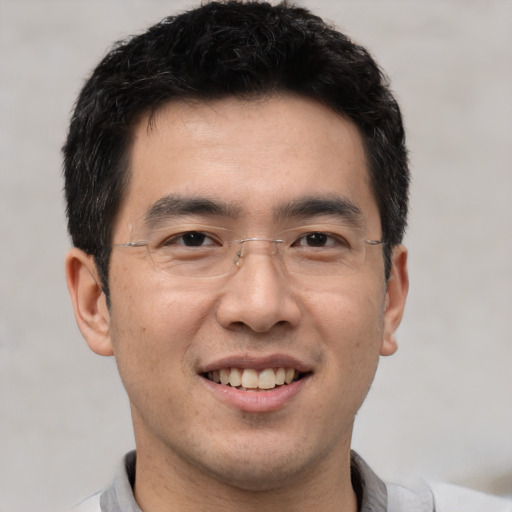 Joyful asian young-adult male with short  black hair and brown eyes