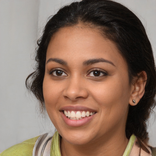 Joyful latino young-adult female with medium  brown hair and brown eyes