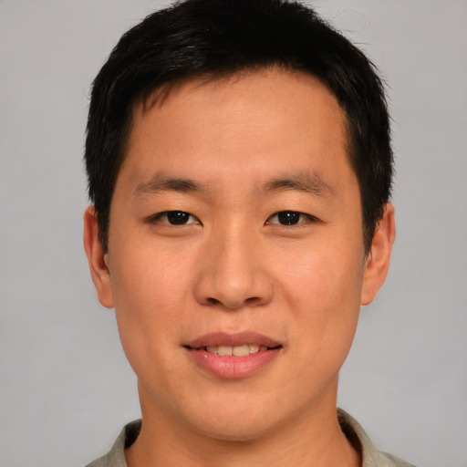 Joyful asian young-adult male with short  brown hair and brown eyes