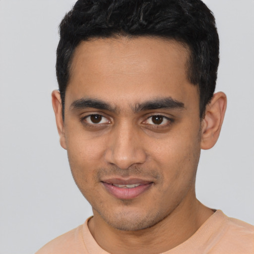 Joyful latino young-adult male with short  black hair and brown eyes