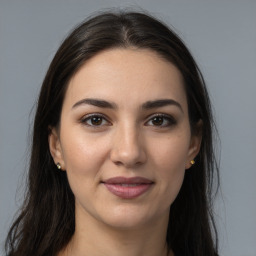 Joyful white young-adult female with long  brown hair and brown eyes