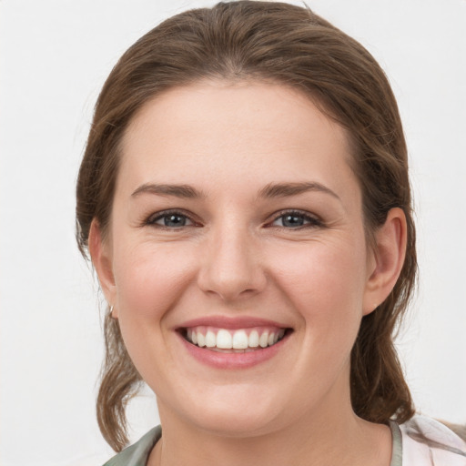 Joyful white young-adult female with medium  brown hair and grey eyes