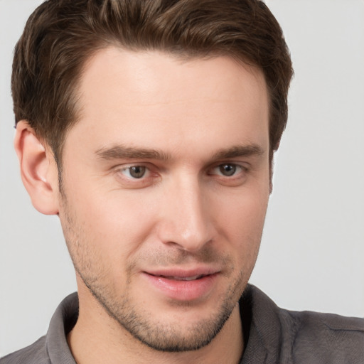 Joyful white young-adult male with short  brown hair and grey eyes