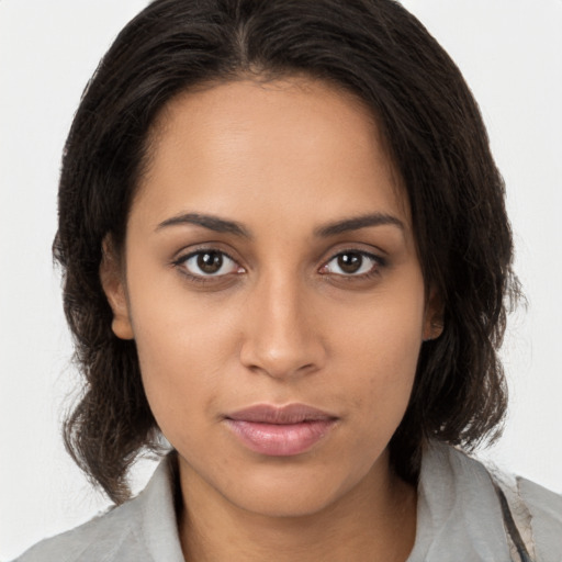 Joyful latino young-adult female with medium  brown hair and brown eyes