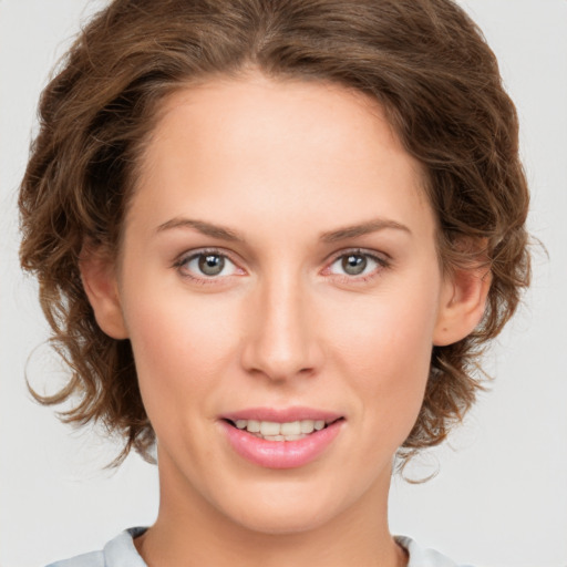 Joyful white young-adult female with medium  brown hair and green eyes