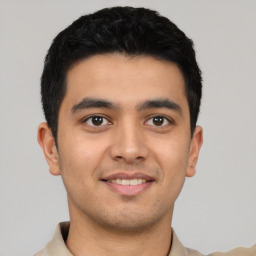 Joyful latino young-adult male with short  brown hair and brown eyes