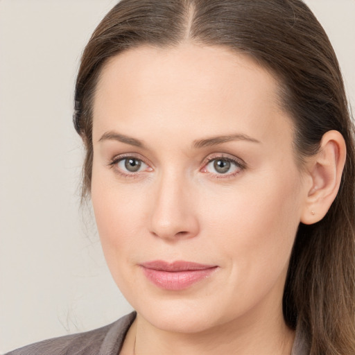 Joyful white young-adult female with long  brown hair and grey eyes