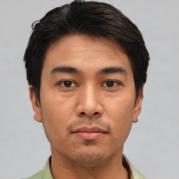 Joyful asian young-adult male with short  brown hair and brown eyes