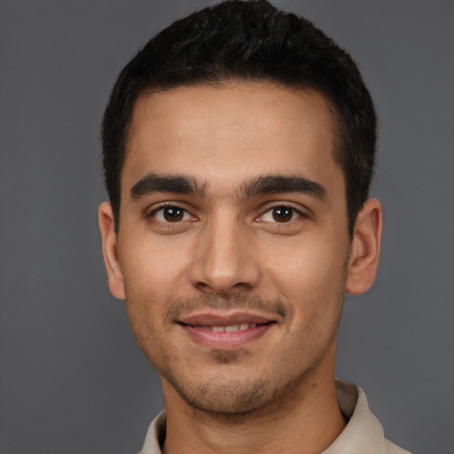 Joyful latino young-adult male with short  brown hair and brown eyes